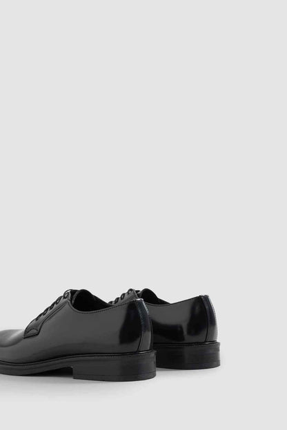 Black leather lace-up derby shoes, side view with cap toe detail