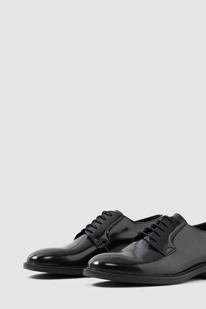 Black leather lace-up derby shoes, angled front view