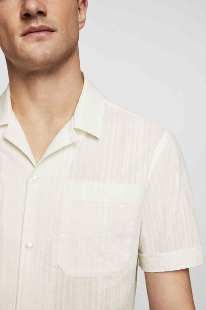 Men's off-white short-sleeve button-up shirt close-up of collar and chest pocket