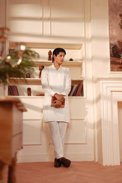 Men's white kurta and pants set, side view with hands clasped
