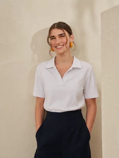 White short-sleeve blouse with pointed collar; dark high-waist wide-leg trousers