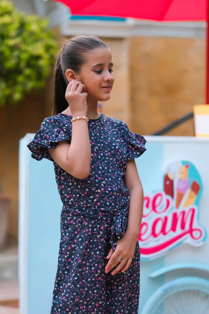 Girls' dark floral jumpsuit with ruffled short sleeves and wide-leg pants, side view
