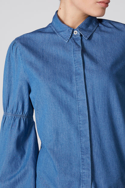 Blue denim shirt jacket detail: button placket and collar