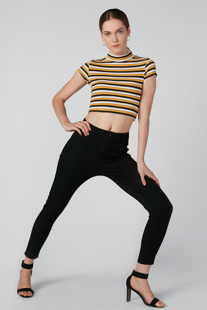 Black ankle pants with striped sleeveless crop top and high neck