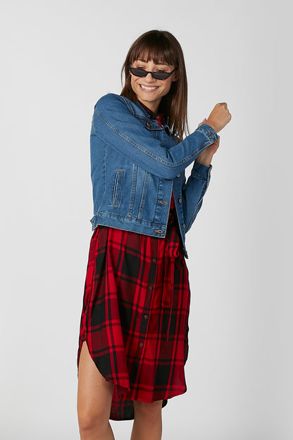 Blue denim jacket with buttoned cuffs and chest pockets, plaid shirt visible
