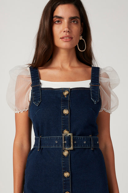 Blue denim pinafore dress with buttoned front and square neckline, sheer puff sleeves