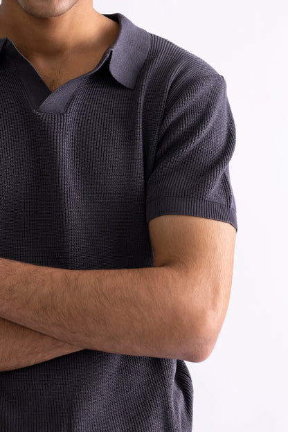 Dark gray knit polo shirt chest detail with fold creases and short sleeves