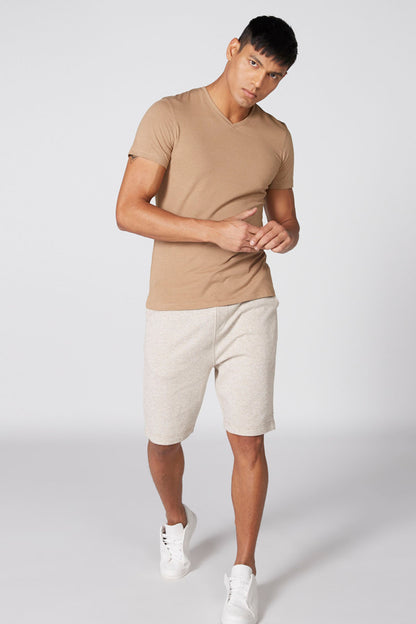 Men's tan V-neck short-sleeve T-shirt and heather-gray drawstring shorts, white sneakers