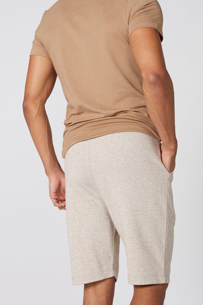 Men's tan V-neck T-shirt with heather-gray drawstring shorts, close-up of sleeves and hem