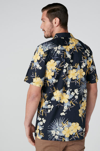 Men's navy short-sleeve button shirt, back view, yellow floral and fireworks print