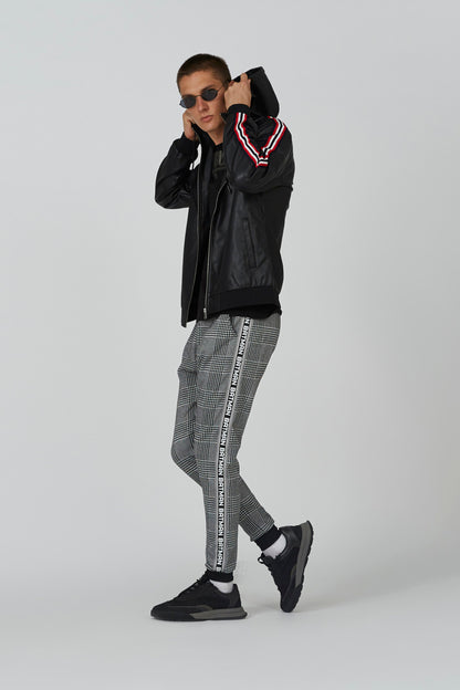Black hooded zip jacket with striped trim; plaid pants visible