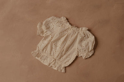 Cream eyelet puff-sleeve blouse with gathered neckline and elastic seams
