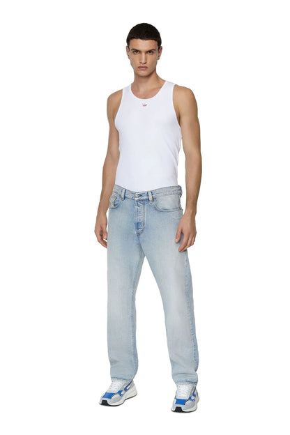 Model wearing light jeans with blue-and-white low-top sneakers