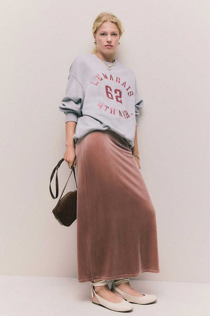 Grey printed sweatshirt with “62” graphic, paired with long rust-brown skirt.