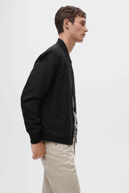 Black bomber jacket side view with ribbed cuffs and hem.