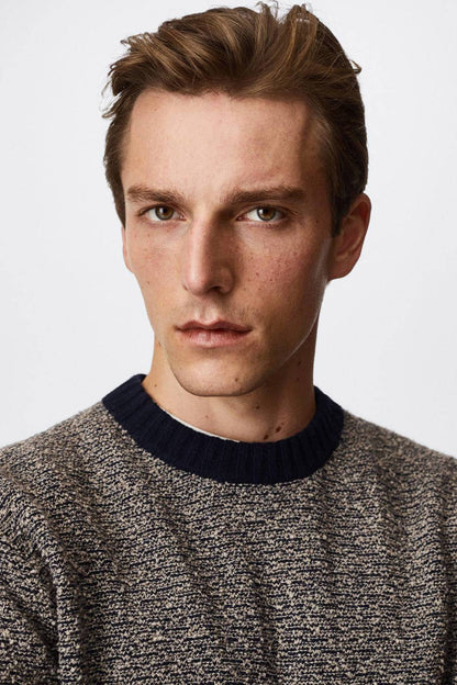 Close-up of men's heather gray knit sweater with navy crew neckline