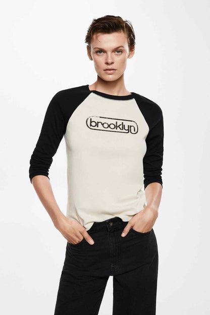 Ecru raglan baseball T-shirt with black sleeves, “brooklyn” logo on chest