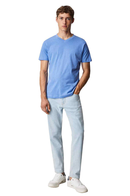 Men's light blue V-neck T-shirt with light-wash jeans, full body view