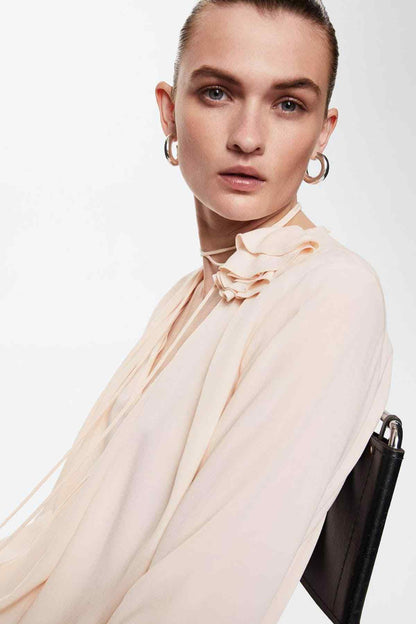 Women’s pastel pink blouse with ruffled neck and thin tie straps