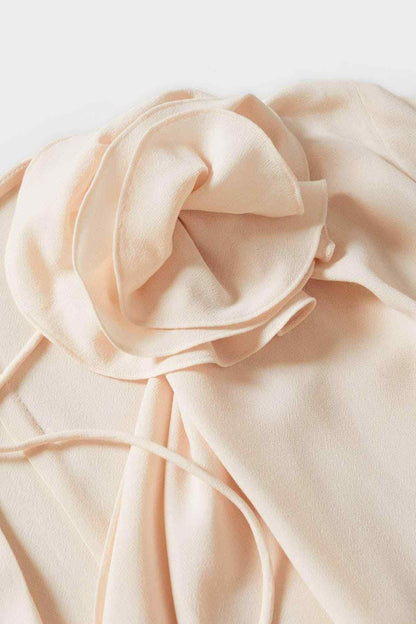Pastel pink blouse fabric close-up with ruffle trim and tie details