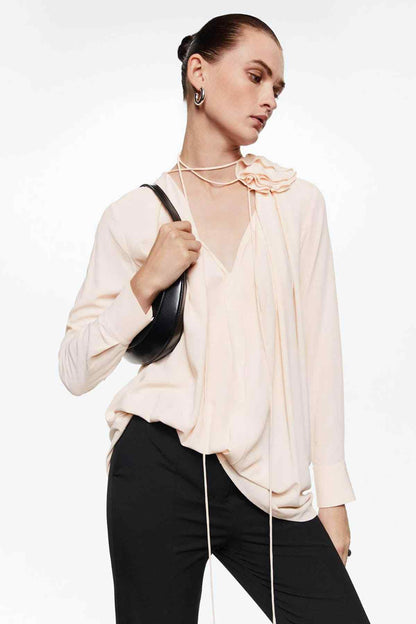 Women’s pastel pink blouse with ruffled neckline, long sleeves, button front
