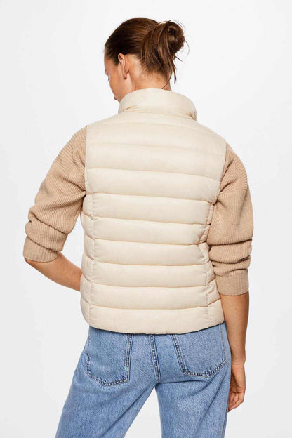 Ecru quilted puffer vest with full back and stand collar, ribbed knit sleeves