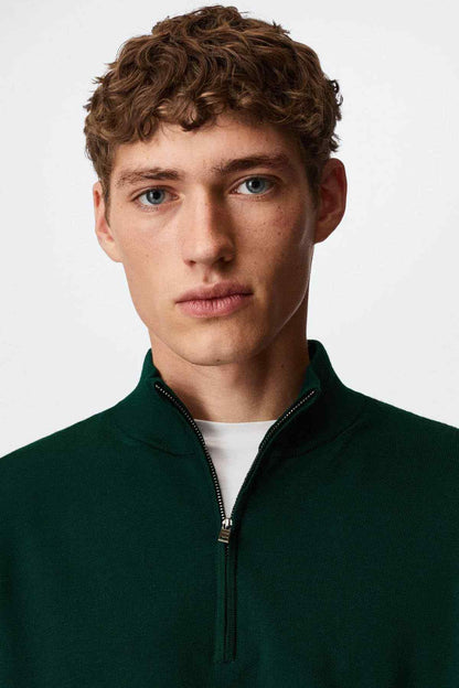Dark green quarter-zip sweater neckline with zipper and ribbed mock collar