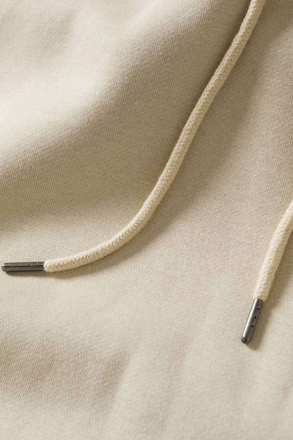 Close-up of ecru hoodie fabric with drawcord and stitching detail