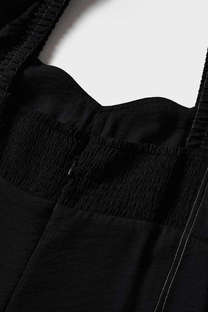 Close-up of black smocked bodice and sweetheart neckline on jumpsuit