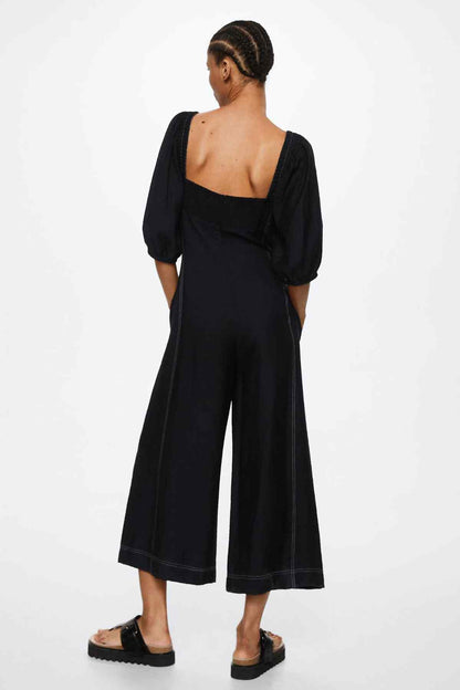 Black backless jumpsuit with puff sleeves and wide-leg cropped pants