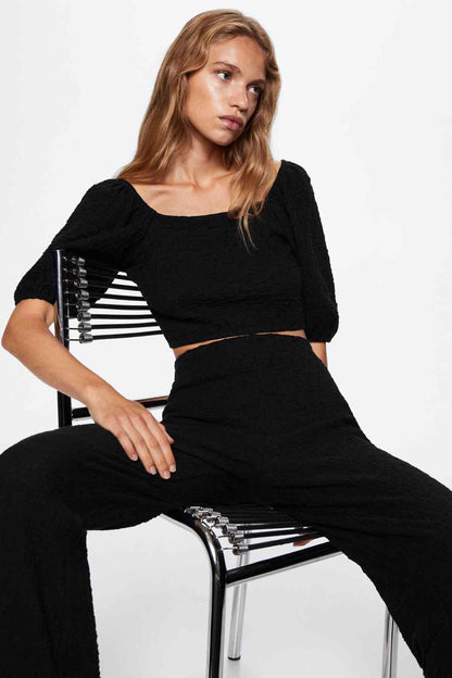 Black wide-leg trousers with gathered-looking waist and straight-to-flare legs