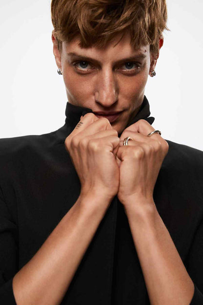 Black blazer with notch lapels and V-shaped neckline opening, close-up of button placket