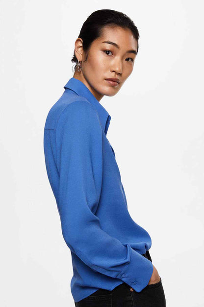 Blue button-up shirt with pointed collar and long sleeves, side profile