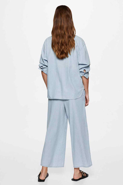 Light blue wide-leg pants with back pleats and relaxed straight legs