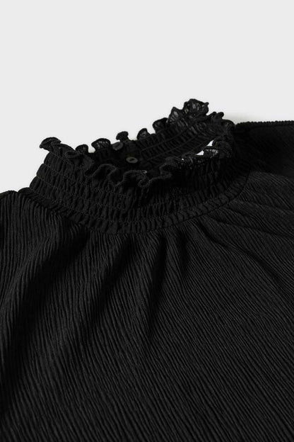 Black blouse neckline with ruffled trim and textured smocking