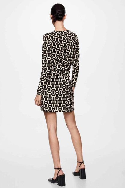 Back view of black and cream geometric print mini dress with long sleeves