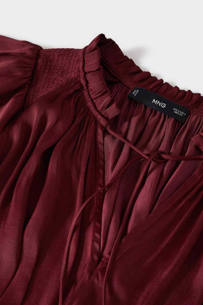 Wine red gathered dress close-up with smocked trim and brand label