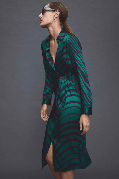 Side view of green and dark striped midi dress with button front and tie belt