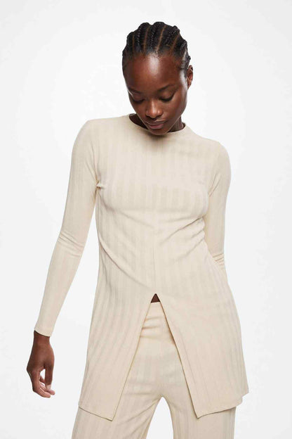 Beige long-sleeve tunic with side slit and striped wide-leg pants, front view
