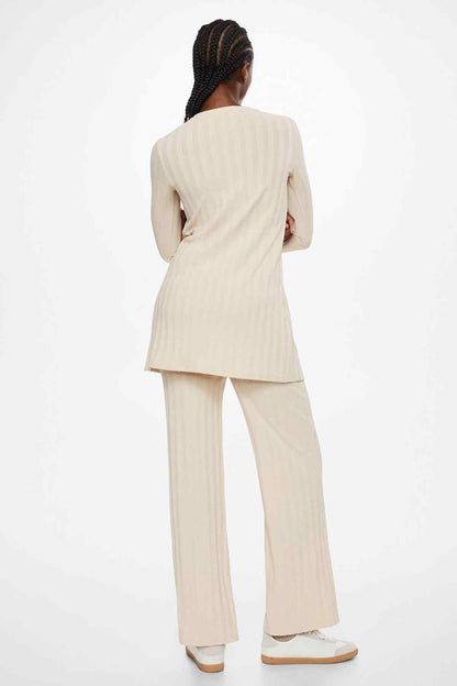 Beige long-sleeve tunic and striped wide-leg pants, back view