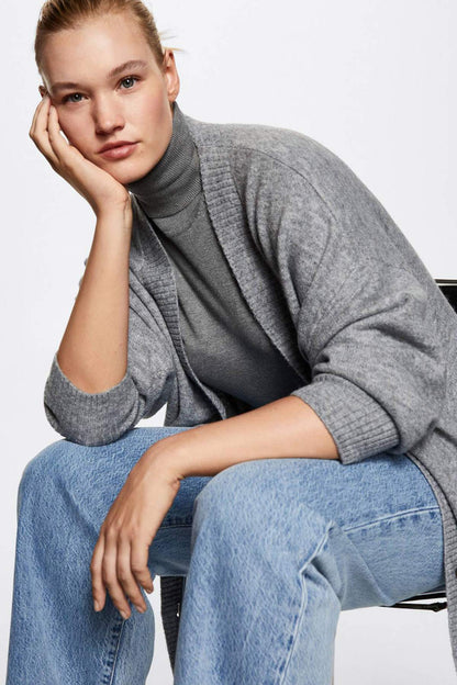 Grey knit cardigan with high collar and long sleeves, styled with blue jeans