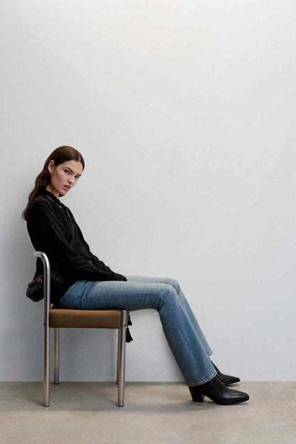 Black long-sleeve blouse with draped front and choker-style tie