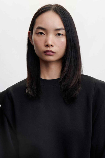 Black crewneck mini dress close-up, smooth fabric and neckline