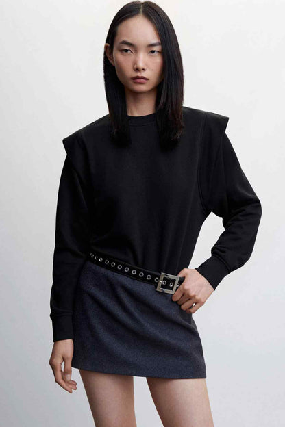 Black crewneck mini dress with long sleeves and belt buckle at waist