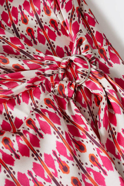 Fuchsia patterned waist tie and knotted belt detail on a wrap dress