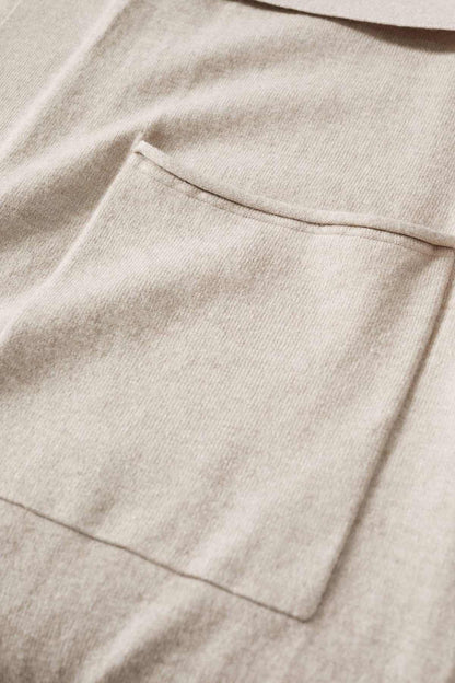 Beige-grey cardigan fabric close-up with stitched pocket opening and seam details