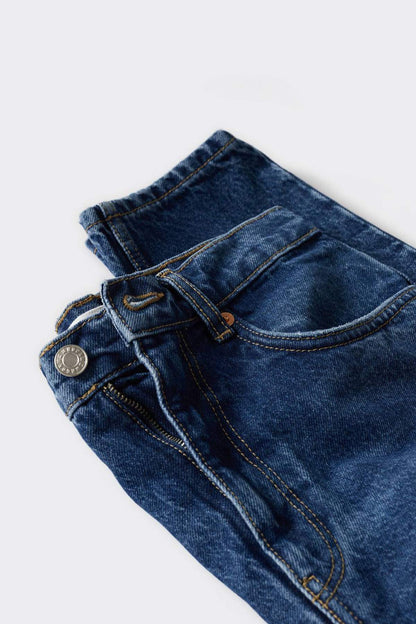 Dark blue denim jeans close-up: belt loops, button waist, and zip fly detail.