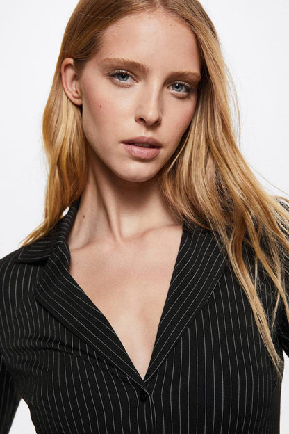 Black pinstripe blazer close-up with notched lapel and buttoned neckline