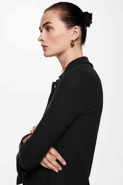 Black knit button-up jacket in side profile, pointed collar and front button placket