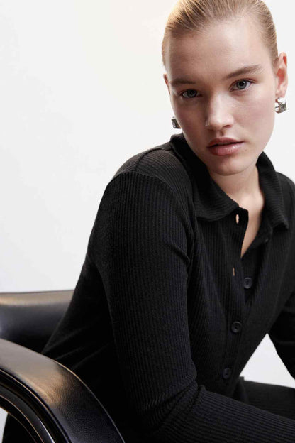 Black knit button-up jacket close-up of collar and front button placket with long sleeves